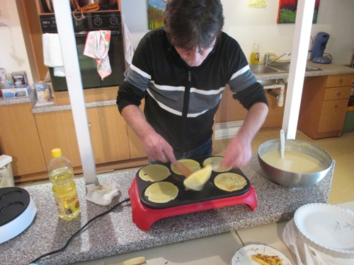 Denis, bénévole à Paris, qui prépare des crêpes pour les adhérents